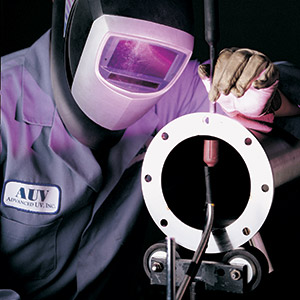AUV engineer tech wearing a welding helmet working on a stainless steel cylinder unit