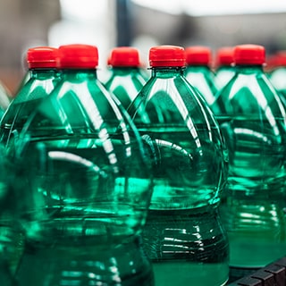 Green bottles processing in line at beverage plant